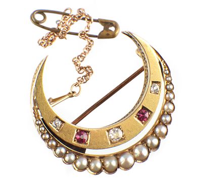 AN UNHALLMARKED YELLOW GOLD CRESCENT SHAPED BROOCH mounted with a band of graduated pearls and 