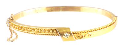 AN UNHALLMARKED 15CT YELLOW GOLD BANGLE of rope twist design with small diamond a joining 