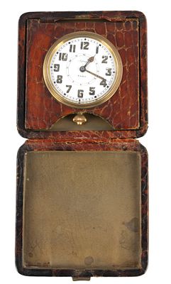 AN EARLY 20TH CENTURY CROCODILE SKIN ASPREY TRAVELING ALARM CLOCK, the hinged wallet type case 
