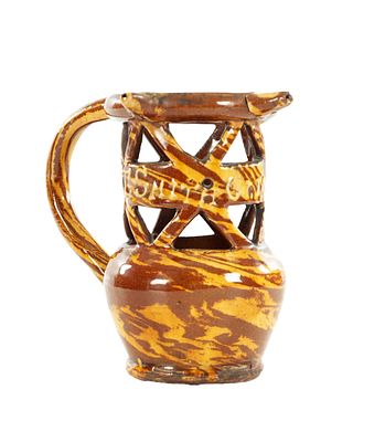 AN EARLY 20TH CENTURY CLITHEROE SLIPWARE PUZZLE JUG having the traditional puzzle jug form 