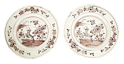A PAIR OF 18TH CENTURY MANGANESE DELFTWARE PLATES the centre of the plates depicts pancing 