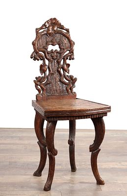 A 19TH CENTURY BLACK FOREST CARVED WALNUT SIDE CHAIR with a pierced foliate back carved as a 
