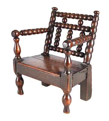 A GOOD 18TH CENTURY WALNUT BOBBIN TURNED CHILD'S CHAIR having a boarded seat, turned arms and 
