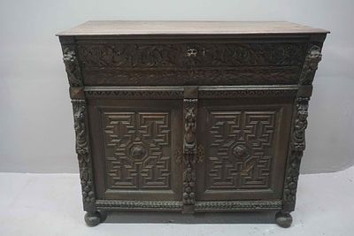 Oak cupboard/bahut, a richly carved piece of furniture with two doors and a trapdoor above. 