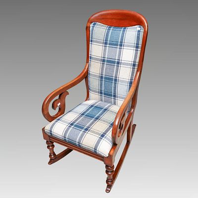 An early 20th Century mahogany framed rocking chair, with carved scroll open arms, upholstered 