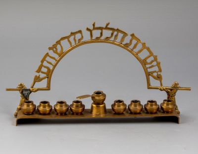 חנוכיית פליז, כנען-צפת. חנוכיית פליז תוצרת כנען-צפת, שנות ה-50. גובה: 14 ס"מ, רוחב: 25 ס"מ. פגם 