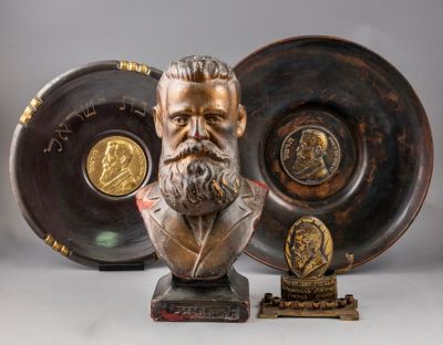 פריטים עם דמות הרצל. לוט ארבעה פריטים עם דמות תאודור הרצל, הכולל: שתי צלחות עם דמות הרצל במרכזן 