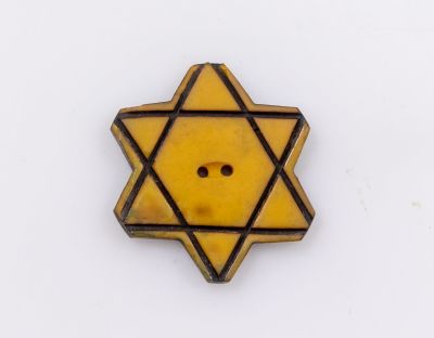 כפתור טלאי צהוב, בולגריה. כפתור צהוב בצורת מגן דוד עשוי צלולואיד. בולגריה, תקופת מלה"ע השנייה. 