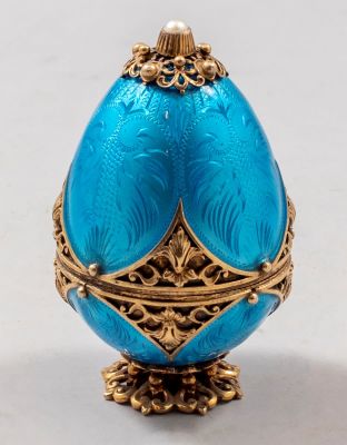 קופסת כסף ואמייל וינאית בצורת ביצה, מעוטרת בעבודת פיליגרן ופנינה בראשה. מוזהבת. גובה: 7 ס"מ. 