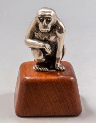 פסלון מכסף, דמות קוף. פסלון מכסף בדמות קוף, ככל הנראה נורבגי, בסיס מעץ טיק. גובה: 9.5 ס"מ. חתום.