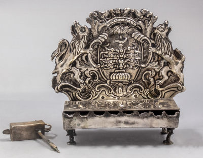 חנוכיית כסף גרמנית איכותית, פרנקפורט, המאה ה-18. מורכבת משני חלקים: גב החנוכייה מעוטר בקרטוש 