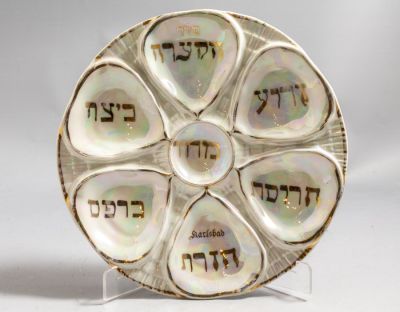 צלחת פסח מפורצלן, קרלסבאד, שנות ה-20 בקירוב, כיתוב בהזהבה. קוטר: 23 ס"מ. חתומה. שחיקה קלה 