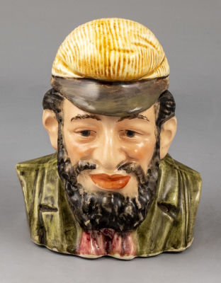 מיכל פורצלן לטבק, דמות יהודי. מיכל פורצלן לטבק, מעוצב בדמות יהודי (ראש). ראשית המאה ה-20. גובה: 