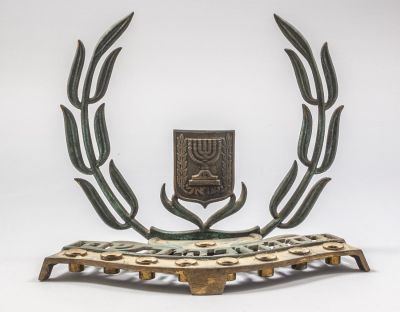 חנוכיית פליז, פל בל. חנוכיית פליז ישראלית תוצרת פל-בל, גב מעוטר עלי זית וסמל המדינה. רוחב: 24 