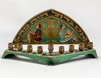 חנוכיית פליז תוצרת דייגי. חנוכיית פליז ישראלית תוצרת דייגי, מעוטרת בדמויות וכד. גובה: 11 ס"מ 