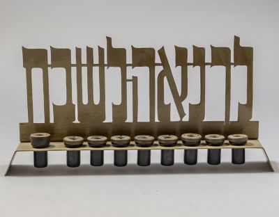 חנוכייה תוצרת ביר. חנוכיית פליז ישראלית תוצרת ביר עם הכיתוב: "לך נאה לשבת". רוחב: 29 ס"מ. חתומה.