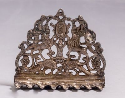 חנוכיית כסף מיניאטורית בסגנון איטלקי. מעוטרת בעבודת חסר בדמויות, צמחים וחיות. גובה: 6 ס"מ 