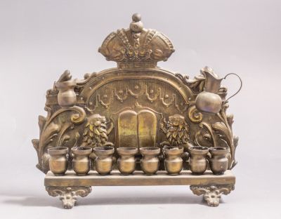 חנוכייה פולנית מצופה כסף, 1900 בקירוב. מעוטרת בעבודת בלט עם אריות, לוחות הברית, מוטיבים צמחיים 