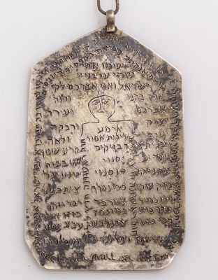 קמע כסף יהודי מעוטר בדמות ובכיתובים בעברית. שרשרת לא מכסף. מידות הקמע: 9X5.5 ס"מ. משקל הקמע: 35 