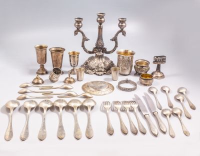 פריטי כסף. מקבץ פריטי כסף שונים, כולל: פמוט תלת קני, כוס קידוש, גביעים, מזלגות ועוד. בנוסף שני 