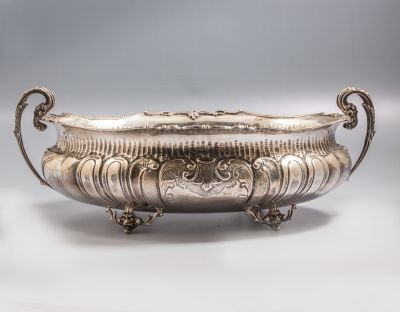 סנטר פיס גרמני מכסף, מעוטר בעבודת בלט עם מוטיבים צמחיים. ניצב על 4 רגליים. מידות: 25X12X40 ס"מ. 