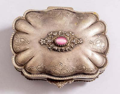 קופסת כסף איטלקית משובצת אבן חן ומעוטרת בעבודת חריטה עם מוטיבים צמחיים. ניצבת על 4 רגליים. 