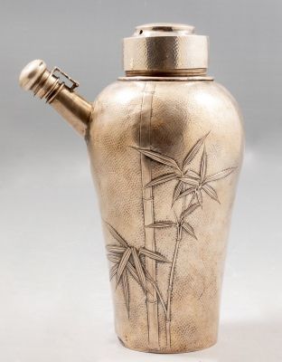 שייקר אמריקאי מכסף סטרלינג, בסגנון יפני. מעוטר בעבודת בלט עם מוטיבים צמחיים. גובה: 20 ס"מ. 