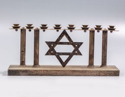 חנוכיית אר דקו מצופה כסף. מעוטרת במגן דוד. מידות: 12X26 ס"מ. חתומה. שמש חסר.