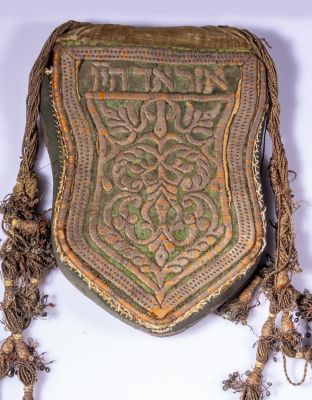 תיק מרוקאי לתפילין. תיק לתפילין, מרוקו, 1920 בקירוב. רקום בעבודת יד, כולל כיתוב בעברית וגדילים. 