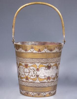 דלי פליז דמשקאי. דלי פליז איסלאמי, משובץ כסף ונחושת בטכניקת דמשק. מעוטר בחיות, ערבסקות ומוטיבים 