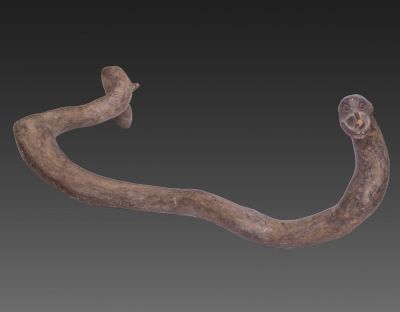 מקל עץ טקסי, פפואה גינאה החדשה, תחילת המאה ה-20. מגולף בצורת נחש. אורך: 98 ס"מ. רוחב מירבי של 