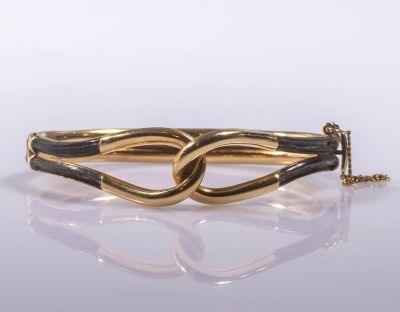 צמיד זהב וקרן. צמיד זהב 14K בצורת לולאות. משובץ קרן. מידות פנימיות: 5.5X5 ס"מ. משקל כולל: 24.7 