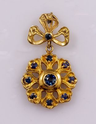 תליון זהב וספירים. תליון זהב 18K בצורת פרח, משובץ 10 ספירים. מידות: 40X25 מ"מ, משקל: 9.4 גרם. חתום.