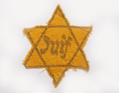 טלאי צהוב מבד, צרפת, תקופה מלחמת העולם השנייה. מידות: 10.5X8.5 ס"מ. בלאי קל.