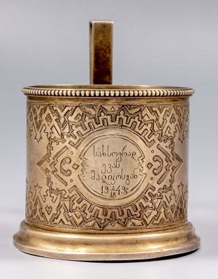 מחזיק לכוס רוסי מכסף 84, 1889. מעוטר בעבודת חריטה עם מוטיבים גיאומטריים ונושא כיתוב מאוחר 