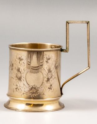 מחזיק לכוס רוסי מכסף 84, 1910 בקירוב. מעוטר בעבודת חריטה עם מוטיבים צמחיים. גובה (כולל הידית): 