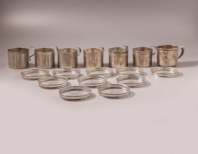 מחזיקי כוסות מכסף ותחתיות מכסף וזכוכית. לוט 7 כוסות מכסף 833 ו-10 תחתיות מכסף סטרלינג וזכוכית. 