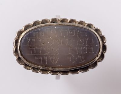 טבעת קמע מכסף משובצת אגט עם כיתוב חרוט ("בן פרת יוסף..."). מידות האגט: 27X18 מ"מ. לא חתומה, כסף 