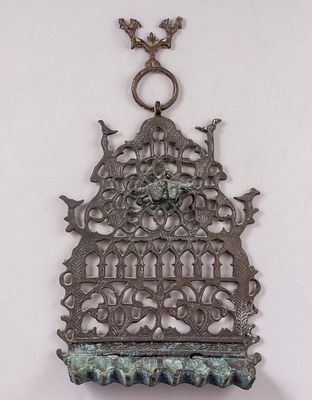 חנוכיית פליז, מרוקו. חנוכיית פליז מרוקאית, ראשית המאה ה-20. מעוטרת בעבודת חריטה וחסר במראה קשתות 