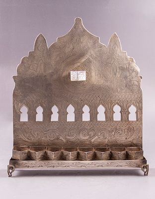 חנוכיית כסף, מרוקו, פז, 1900 בקירוב. גב מעוטר עבודת ניסור וחריטה במראה קשתות ומוטיבים צמחיים. 