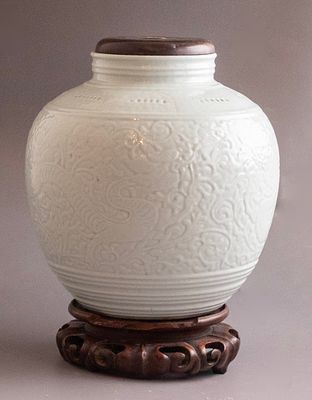 כד פורצלן סיני, שושלת צ'ינג (Qing). מעוטר בדוגמת דרקונים ומוטיבים צמחיים. ניצב על בסיס עץ 