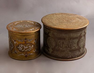 קופסאות פליז, עבודת דמשק. לוט 2 קופסאות פליז איסלאמיות עשויות מפגדים, אחת משובצת כסף ונחושת 