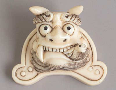 Carved Japanese Netsuke. Japanese netsuke, carved in the form of a Foo dog with a bird. 