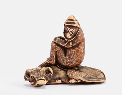 Carved Japanese Netsuke. Japanese netsuke, carved in the form of a monkey wearing a hat and 
