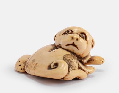 Carved Japanese Netsuke. Japanese netsuke, Edo period. Carved in the form of a dog with a scarf. 