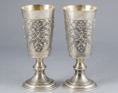 זוג גביעי כסף איטלקים מעוטרים בעבודת בלט, חריטה וריקוע עם מוטיבים צמחיים. גובה: 16.3 ס"מ, משקל: 