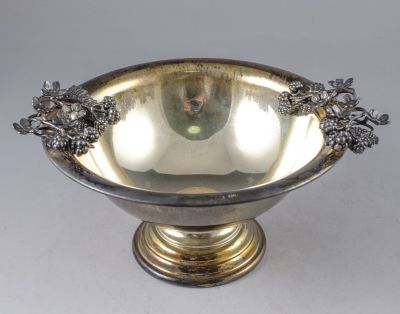 קערת כסף סטרלינג מעוטרת באפליקציות של פרחים. קוטר: 18 ס"מ. משקל: 413 גרם. חתומה ומתוארכת 1952.