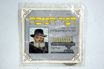 דמי חנוכה לכבוד האדמו"ר מלובביץ', עם מטבעות של 100 שקלים.