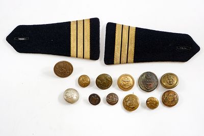 שנים־עשר כפתורים צבאיים שונים, חלקם נדירים, ממלחמת העולם, וזוג דרגות כתף של קצין ימי.