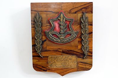 מגן שולחני בשילוב עץ זית וברונזה של צה"ל, שניתן לרגל סיום תפקיד מאת האלוף קצרון, ראש אגף כוח 